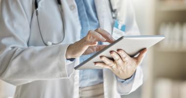 Médico sigue historial clínico de paciente en tableta